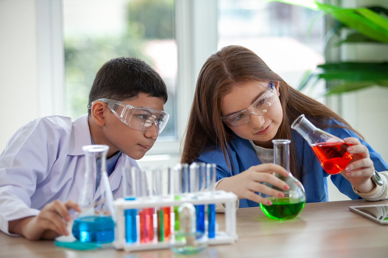  Schüler mischen Chemikalien in Reagenzgläsern