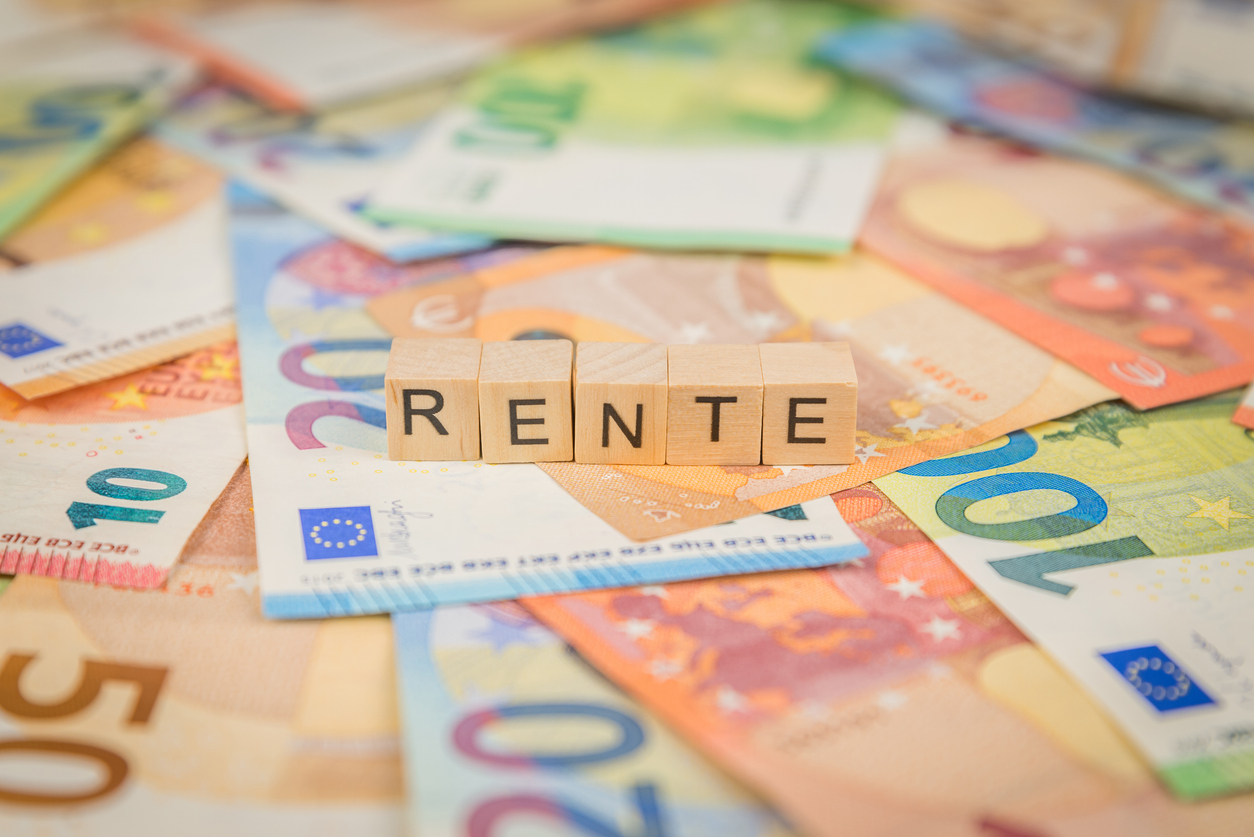 Das Wort Rente - auf Banknoten Euro-Banknoten mit Holzwürfel