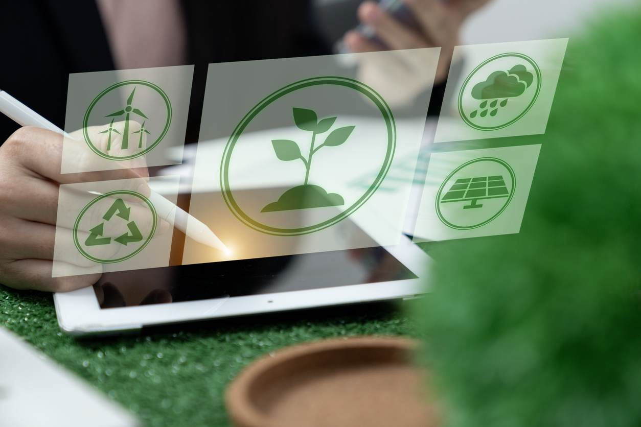 Geschäftsfrauen nutzen ein digitales Tablet, um das ESG-Design zu analysieren.