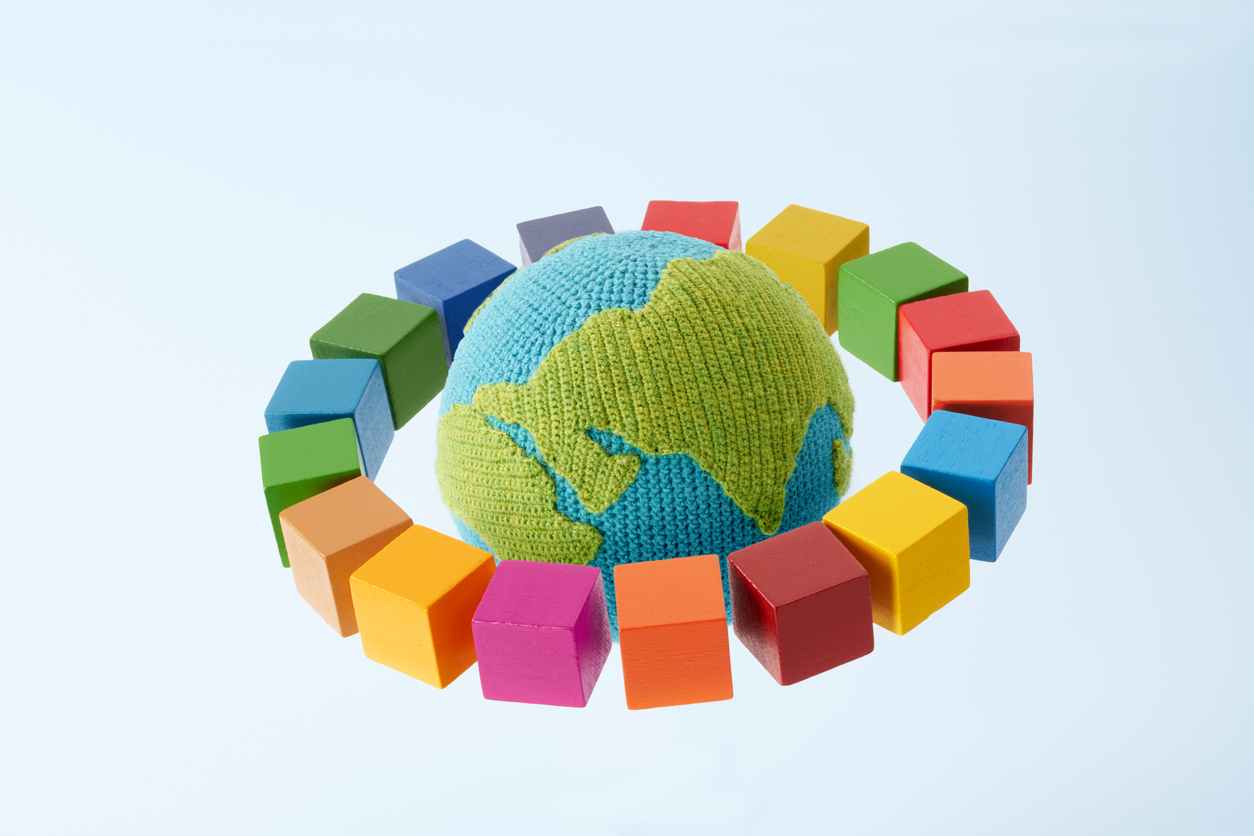 SDGs symbols and a wooden cube with knitted earth