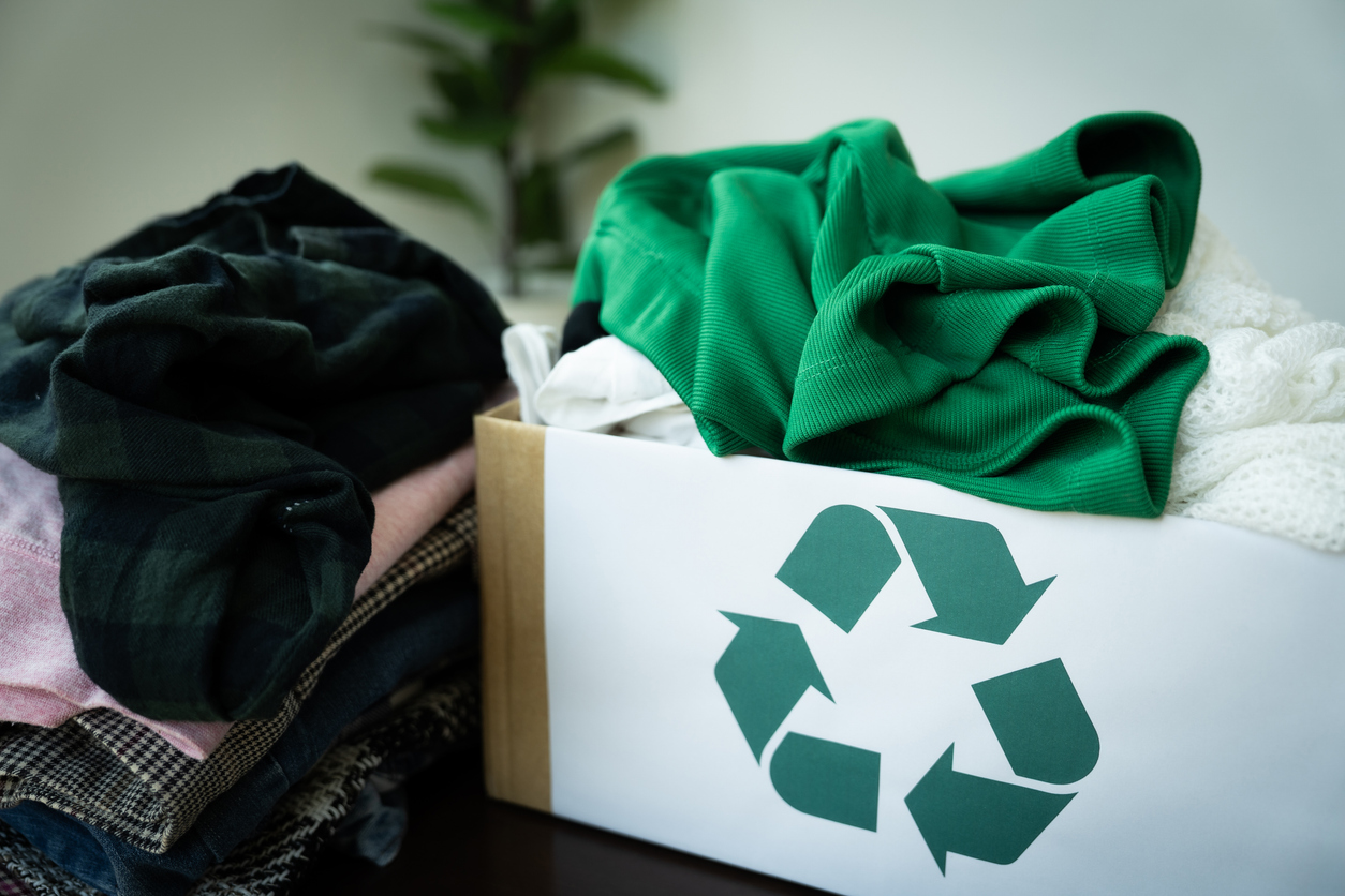 Kiste mit Kleidung mit Recycling-Symbol