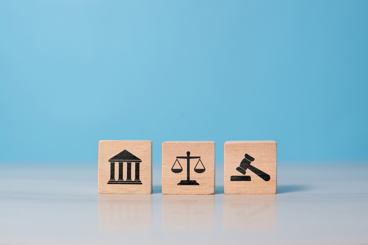 Modernes Rechtskonzept mit Holzwürfeln und Gerechtigkeitssymbolen