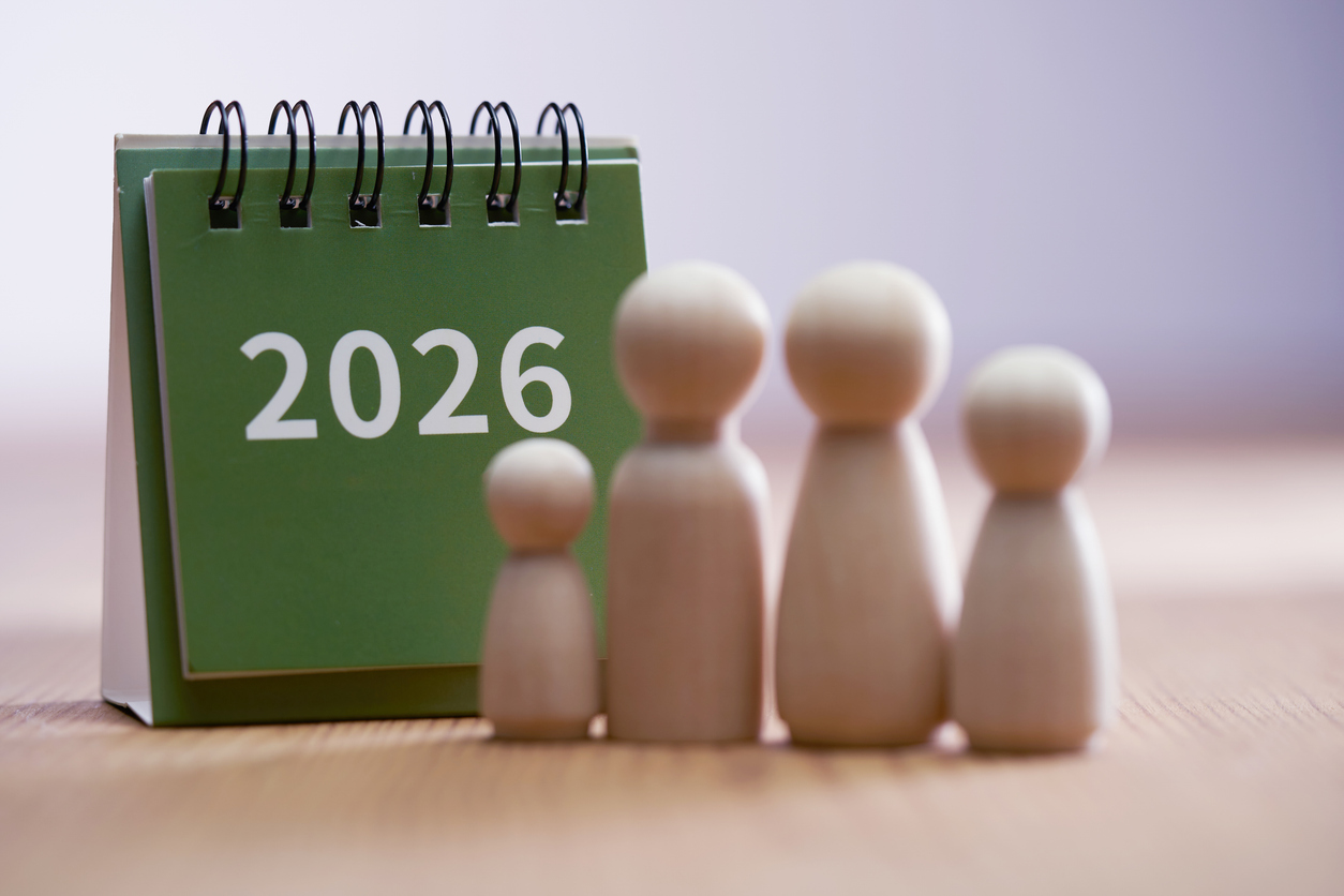 Kalenderblatt 2026 mit vier Holzfiguren, die eine Familie darstellen