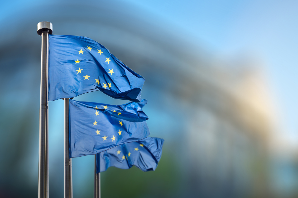 EU-Flaggen vor verschwommenem Gebäude in Brüssel