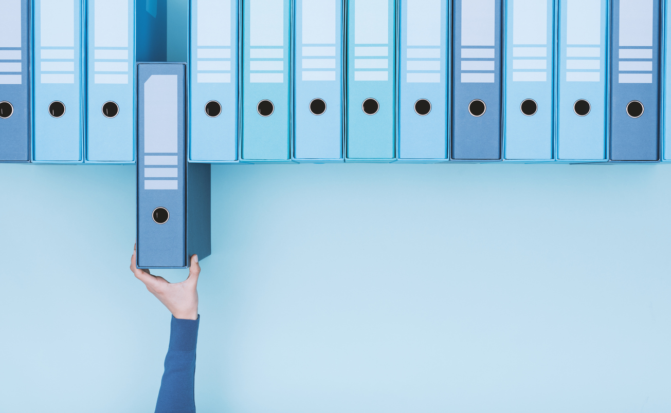 Büroangestellte, die einen Ordner in das Archiv aufnehmen