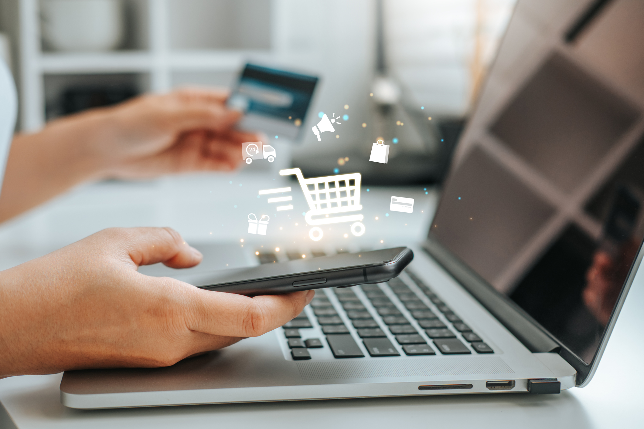 Person am Computer mit E-commerce Symbole wie Einkaufskorb