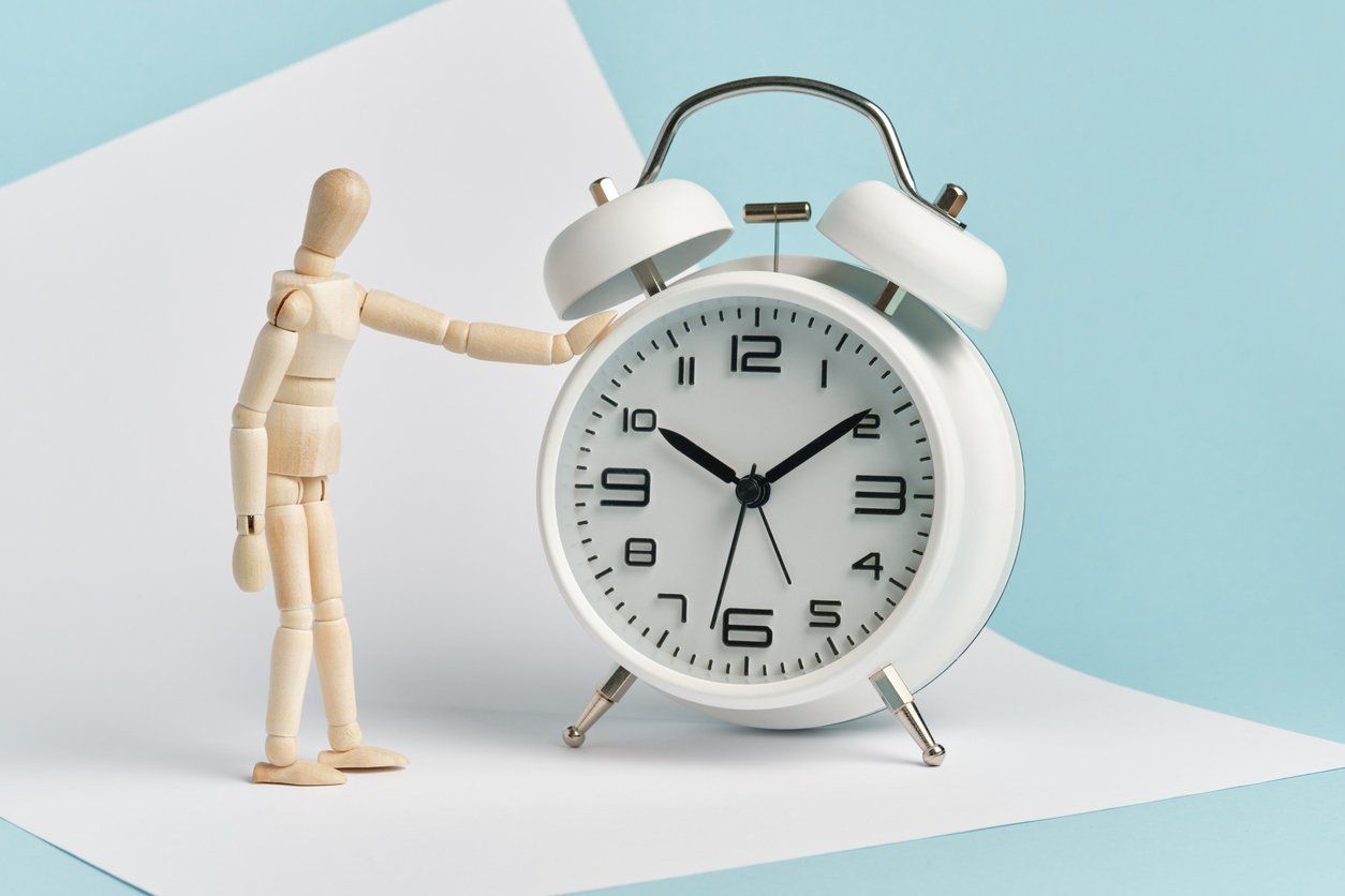 Marionette neben Weckeruhr auf dem Tisch